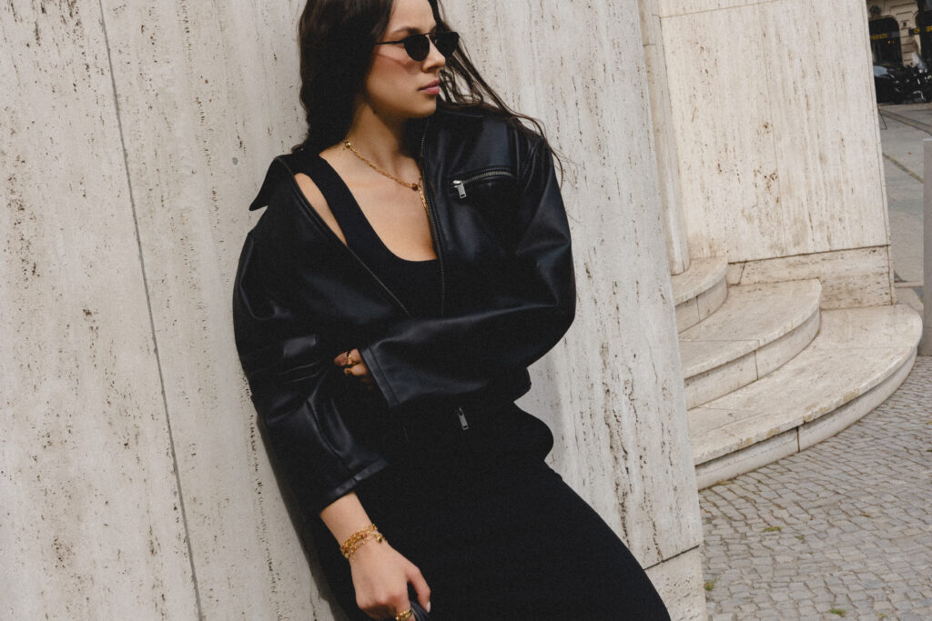 Modelka w czarnej stylizacji i autorskiej biżuterii PARTS JEWELRY podczas sesji modowej w Berlinie, na tle jasnej architektury.