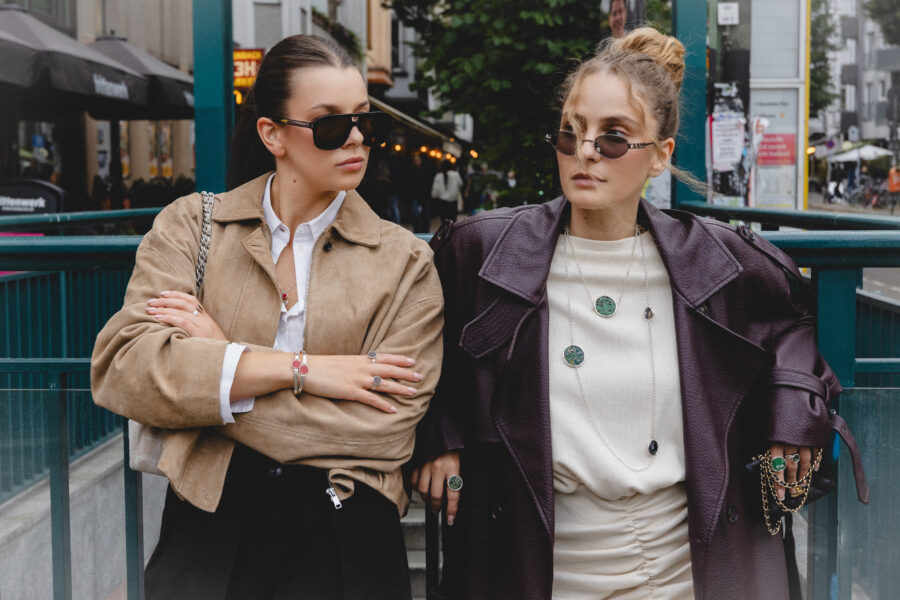 Dwie modelki w minimalistycznych stylizacjach, beżowej koszuli i skórzanej kurtce, prezentują biżuterię PARTS JEWELRY podczas kampanii w Berlinie.