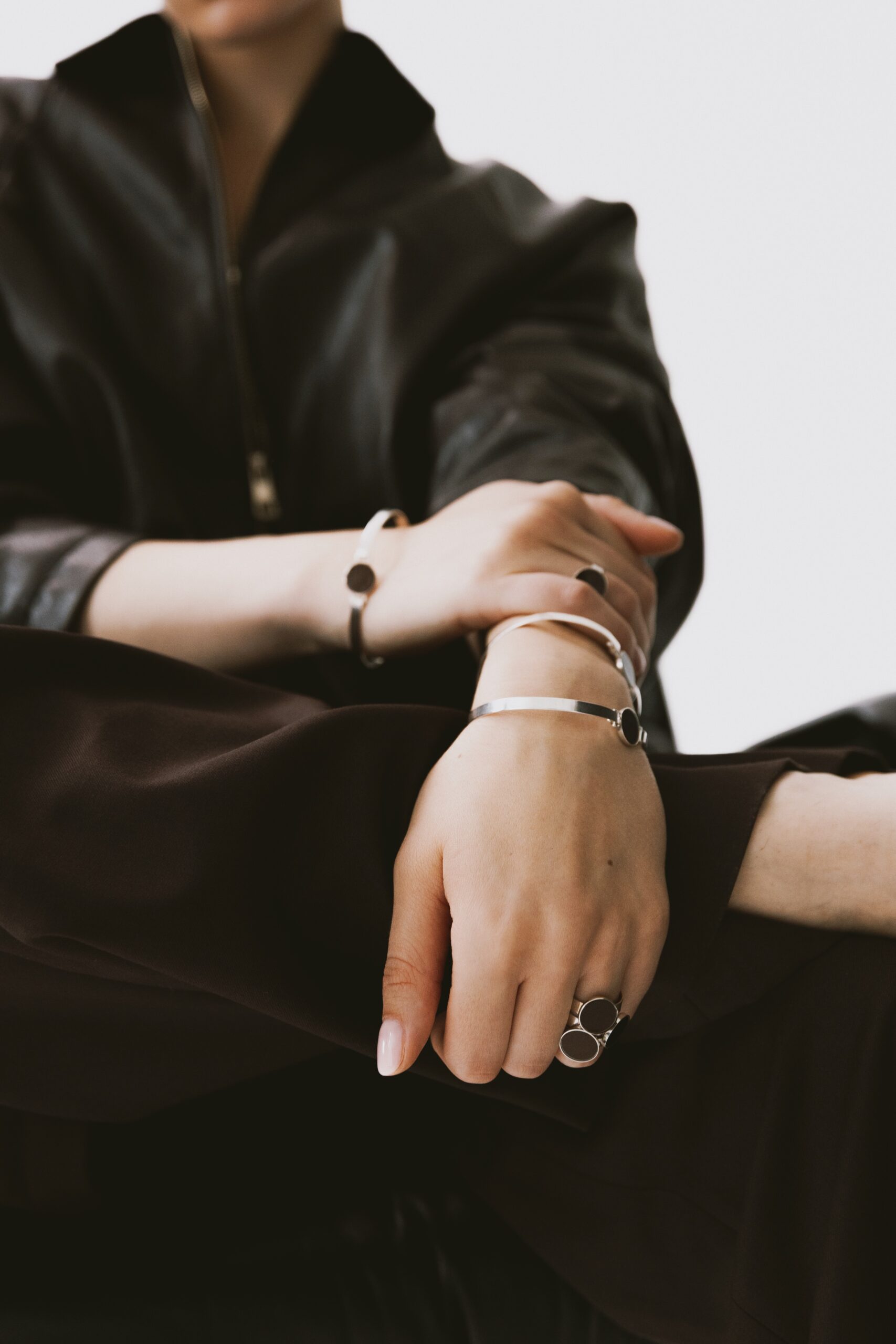 Srebrna bransoletka z brązowym próbnikiem lakieru noszona na nadgarstku