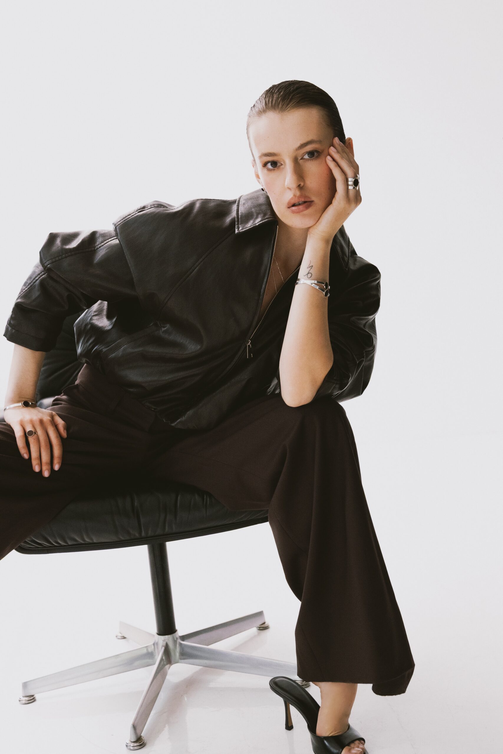 Modelka nosząca srebrną bransoletkę z brązowym próbnikiem lakieru