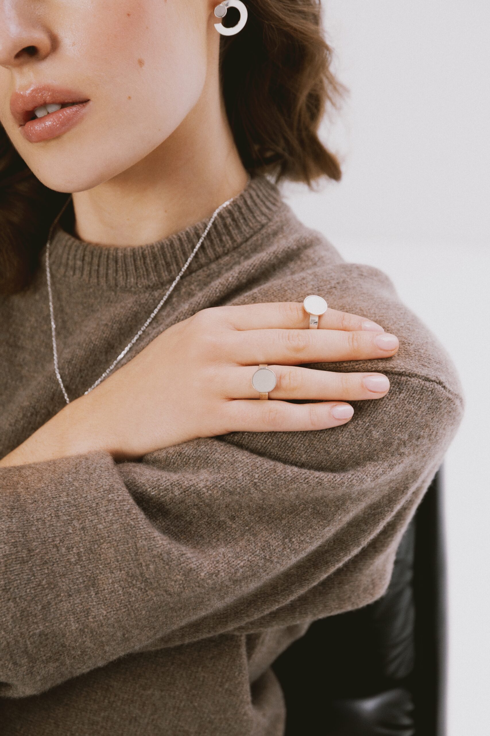 Pierścionek srebrny z jasnoszarym próbnikiem lakieru Volvo noszony na dłoni