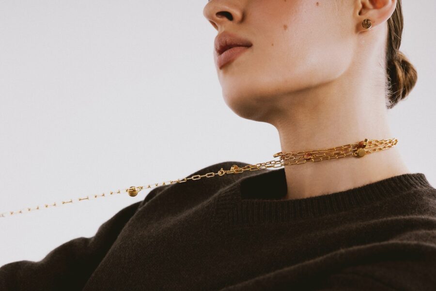 Naszyjnik z kolekcji Inscription z pozłacanego srebra 925 noszony na szyi w minimalistycznej stylizacji
