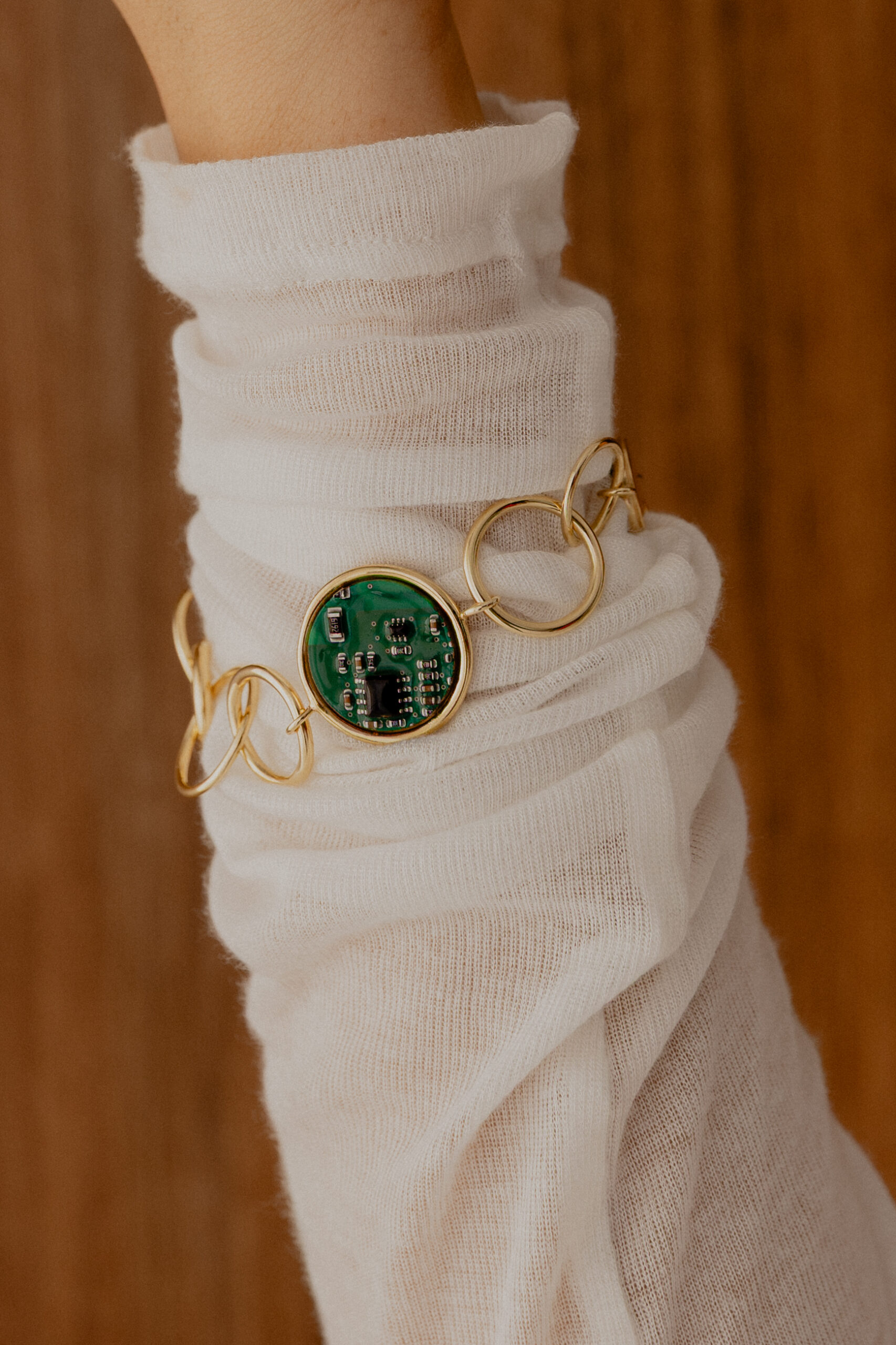 Modelka nosząca pozłacaną bransoletkę Ultra Parts Jewelry z układem scalonym Volvo