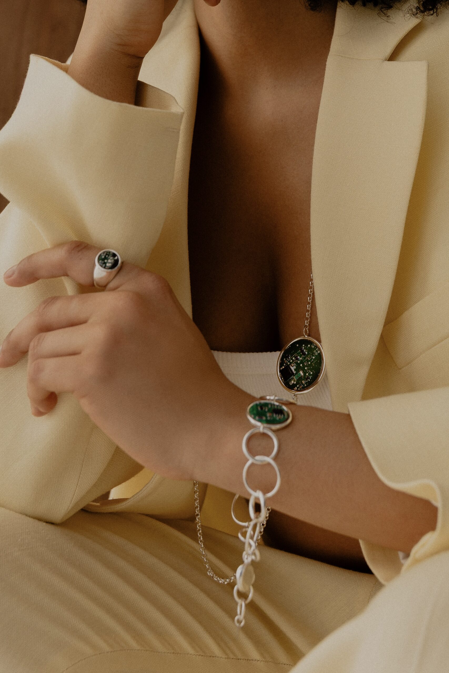 Modelka w kremowym garniturze nosząca bransoletkę i naszyjnik Ultra Parts Jewelry z układami scalonymi Volvo