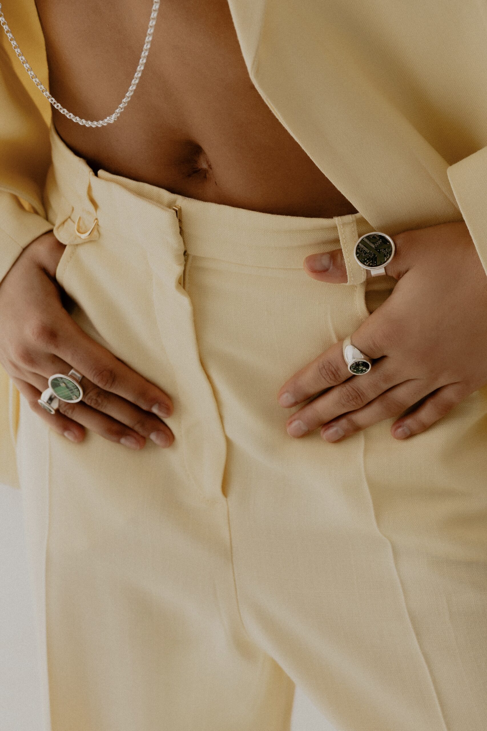 Modelka w kremowym garniturze nosząca pierścionki i naszyjnik Ultra Parts Jewelry z układami scalonymi Volvo