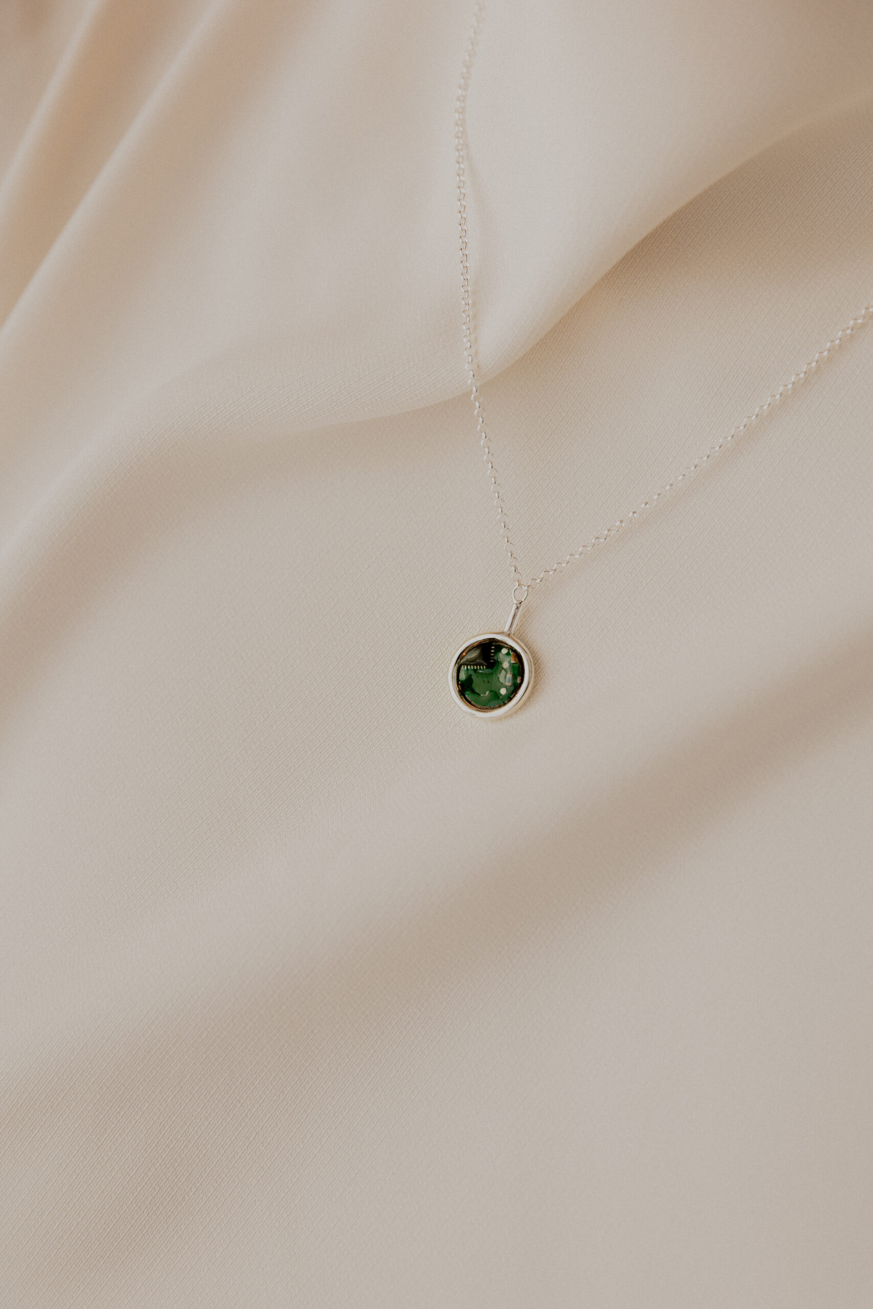 Minimalistyczny naszyjnik Ultra Parts Jewelry z układem scalonym Volvo na jasnym tle